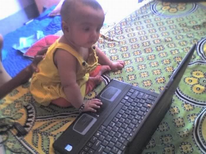 Baby doll playing with laptop